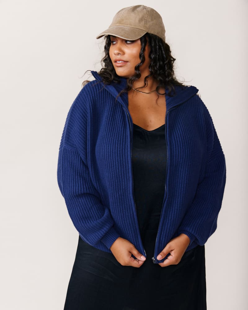 Front of a model wearing a size 2X Norma Zip Front Sweater in Navy by ABLE. | dia_product_style_image_id:271434